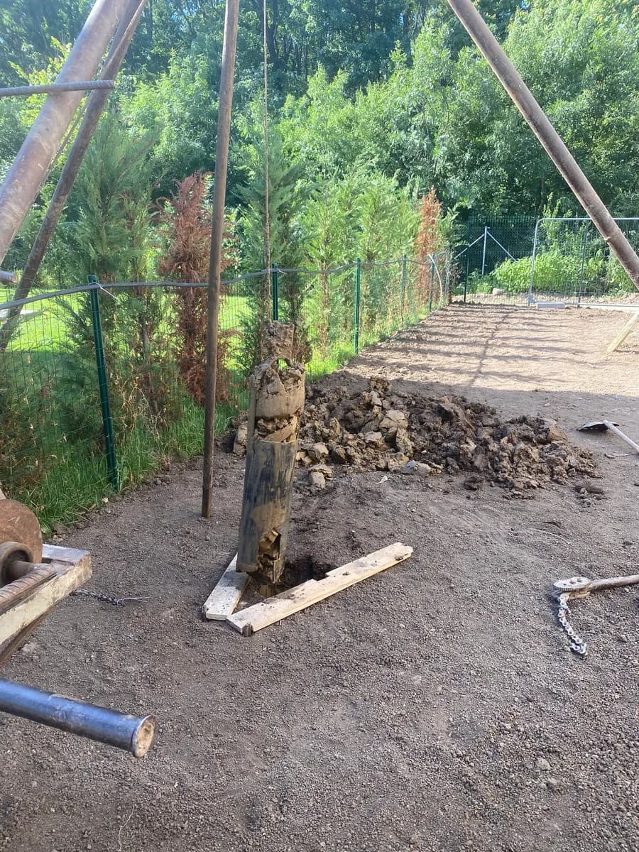 Foraj manual puț apă în grădină, trepied montat lângă gard